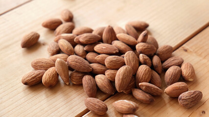 Group of almonds on wooden table background. Healthy vegan snack food