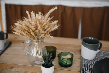 ears of corn in a glass transparent vase on a wooden table in the village