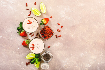 Healthy blended diet smoothie drink with strawberry and goji berries, chia seeds and lime. Top view