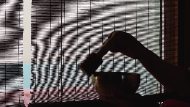 a man's hands touch tibetan bowl