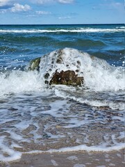 Welle überspült einen Findling in der Ostsee