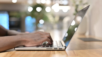 Side View of African Man Hands Typing on Laptop