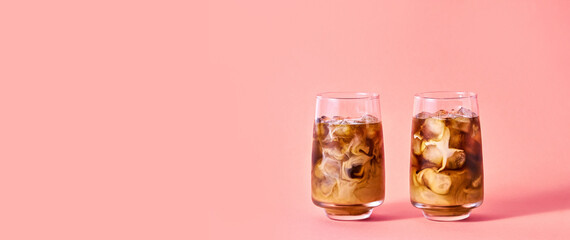 Iced Coffee with Milk in Tall Glasses on Pink Background. Concept Refreshing Summer Drink