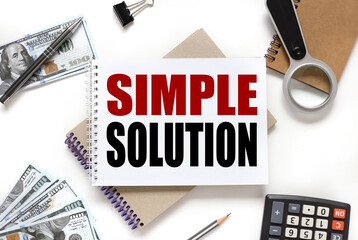 SIMPLE SOLUTION. notebook on white workspace. near the notepad dollar bills and a calculator
