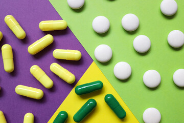 pills of three colors on backgrounds of different colors. background in yellow, purple and green. different personality. vitamins, antiviral, antibiotics.