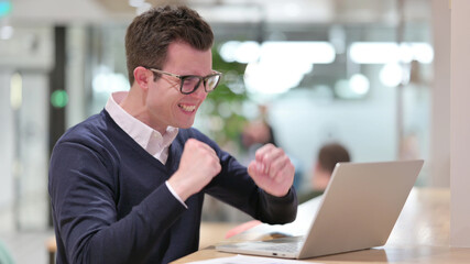 Excited Young Businessman Celebrating Success on Laptop 