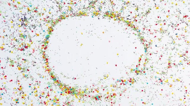 The hand makes a round frame for the inscription in the background of baking sprinkles. Time lapse video, 16x9 format. ProRes 422 HQ.