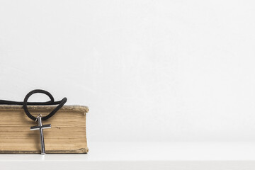Obraz premium Bible with a cross on table.