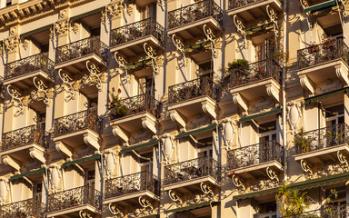 Partial view of the facade of historical house with typical french balconies and walls decoration in Nice, France.