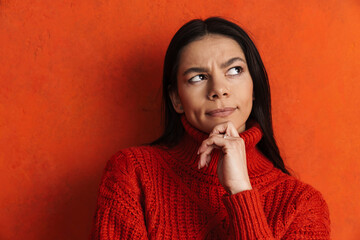 Young hispanic puzzled woman thinking and looking aside