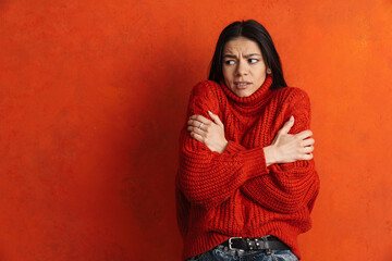 Young hispanic woman wearing sweater shaking from cold