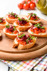 Deliziosi crostini vegetariani con pomodoro, rucola, radicchio e olio di oliva, cucina italiana 
