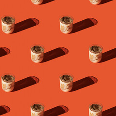 Pattern of tiramisu in cups on orange background