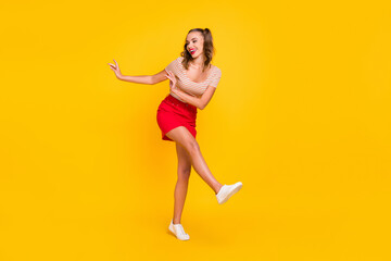 Fototapeta na wymiar Full length body size view of attractive cheerful slender girl dancing having fun isolated over bright yellow color background
