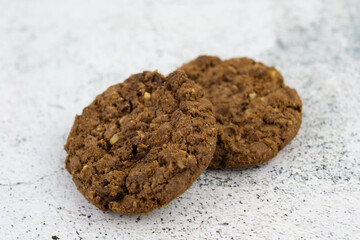 oatmeal cookies on a marble table, dry cake on a white table close-up. sweet rusk, flour sugar product, crisp bread for tea, delicious dessert with nuts,