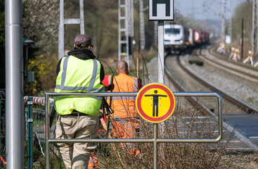 Sanierung Schienen und Bahnstrecke: Arbeiter an einem Bahnübergang oder Bahnhof unterbrechen ihre...