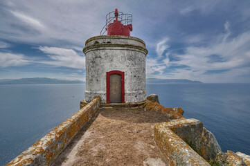 Fototapeta na wymiar small lighthouse on the island of San Martiño within the Cíes Islands. In the background the Vigo estuary