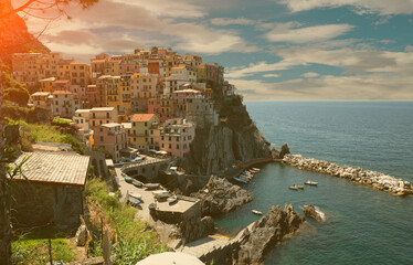 Fototapeta na wymiar Manarola, Liguria, Italy. June 2020. Amazing view of the seaside village. The colored houses leaning on the rock near the sea are particularly fascinating and characteristic. Beautiful summer day.