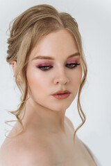 Naklejka premium portrait of a beautiful Caucasian woman with light skin and blonde hair with blue eyes close-up on a white background. attractive young woman with beautiful makeup. skin care, beauty concept