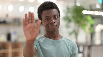 Portrait of Young African Man showing Stop Sign