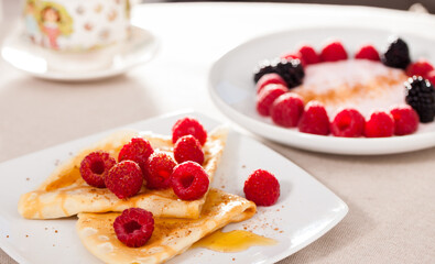breakfast of pancakes with fresh raspberries on table