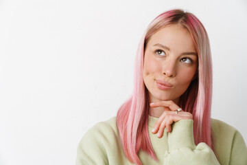 Young white thinking woman with pink hair looking upward