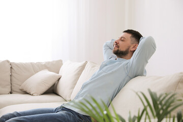 Fototapeta premium Man resting on comfortable sofa in living room