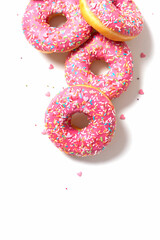 Amazing donuts isolated on white. Top view of yummy fresh homemade doughnuts. Light background for you text. Decorated with confetti in shape of little hearts.