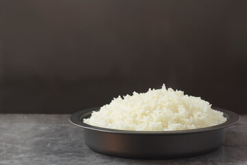 Warm steamed rice, freshly cooked in a steamed bowl, is a staple food for Asians, which are rich in fiber and nutrients with copy space for text.
