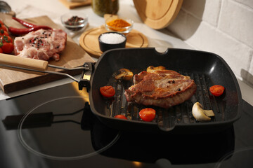 Frying pan with fresh raw meat and vegetables on stove