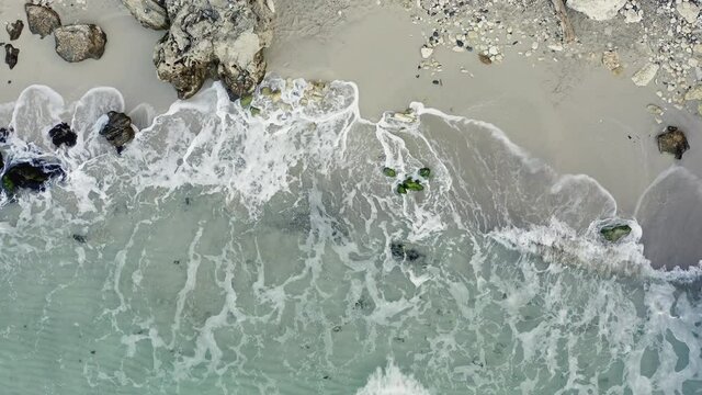 top aerial view sea waves wash the coast with rocks