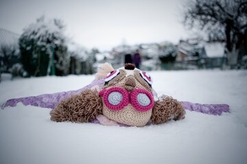 Child in funny cap playing in snow