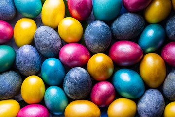 Many colored dyed eggs for the Easter holiday. Background of pink, yellow and blue eggs
