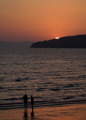 silhouette of a couple walking on the beach