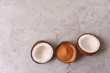 coconut sugar in a coconut shell on a gray stone background from top view with copy space