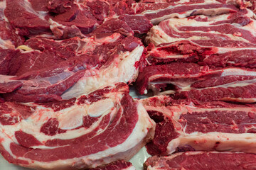Chunks of beef brisket lie on the butcher's counter in the market. Background. Texture.