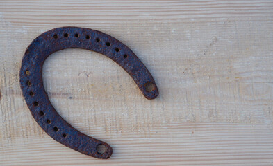 Old rusty horseshoe on a pine board. Natural wood background. Wood texture. Place for text.