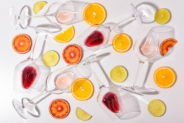 glasses of wine on a white table with sliced citrus fruits