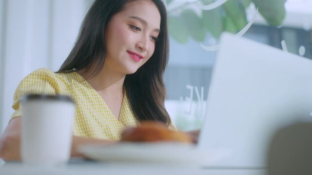 young attractive asian female wear casual cloth hand use smartphone and laptop device comminication social contact in cafe restaruant sit at counter next to big window daylight