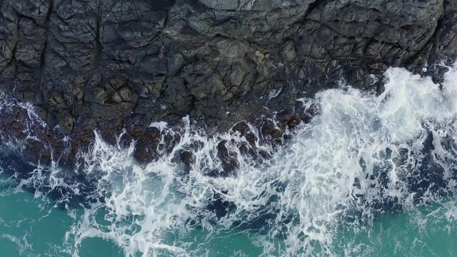white waves wash black rock in sea, beautiful texture