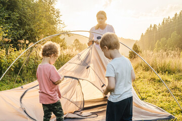 Young woman putting up a tent, summer.