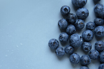 Top down view above or flatlay Heap of Fresh organic picked blueberries after wash on light blue grey plain background and copy space. Healthy eating Low fat and calories for weight control