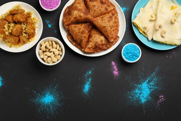 Traditional Indian food and color powders on black background, flat lay. Holi festival celebration