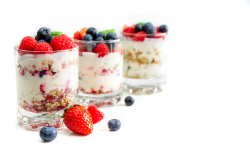Muesli with yogurt and berries in a glass On a white background. Dessert preparation process. Fitness food. Copy space. High quality photo