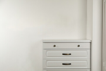 Modern chest of drawers near white wall
