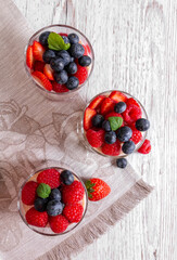 Muesli with yogurt and berries in a glass On a wooden table. Fitness food. Copy space. View from above. Flat lay.High quality photo