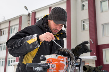 Portrait of a worker repairing a gasoline saw