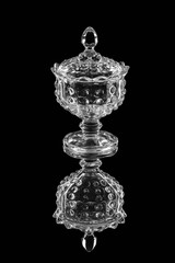 crystal jam vase, with lid, on black mirror background

