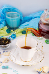 tea ceremony, black fragrant tea, brewed in a teapot, poured into a white cup