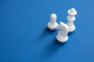 Chess pieces on a bright blue background. Abstract background. White chess figures for the game and...